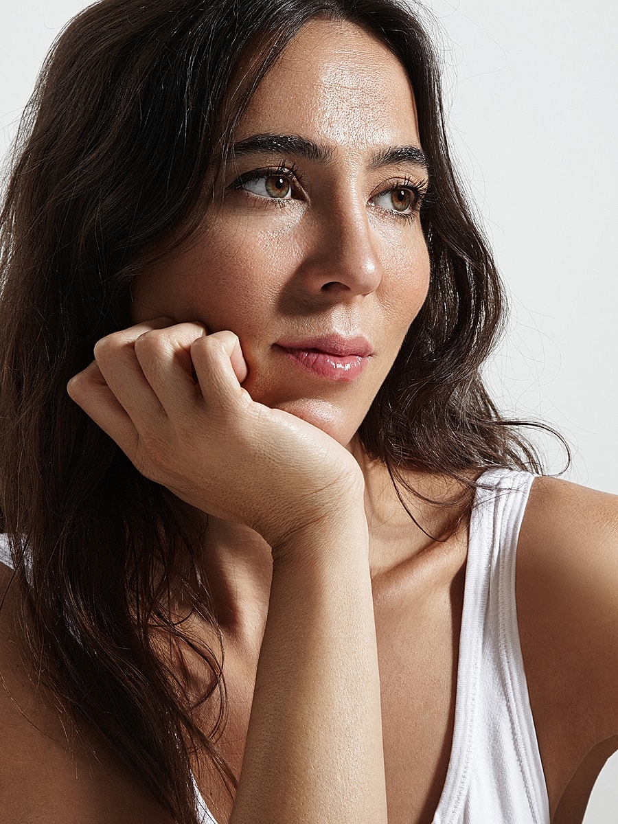 Woman resting her chin on hand, thoughtful expression.