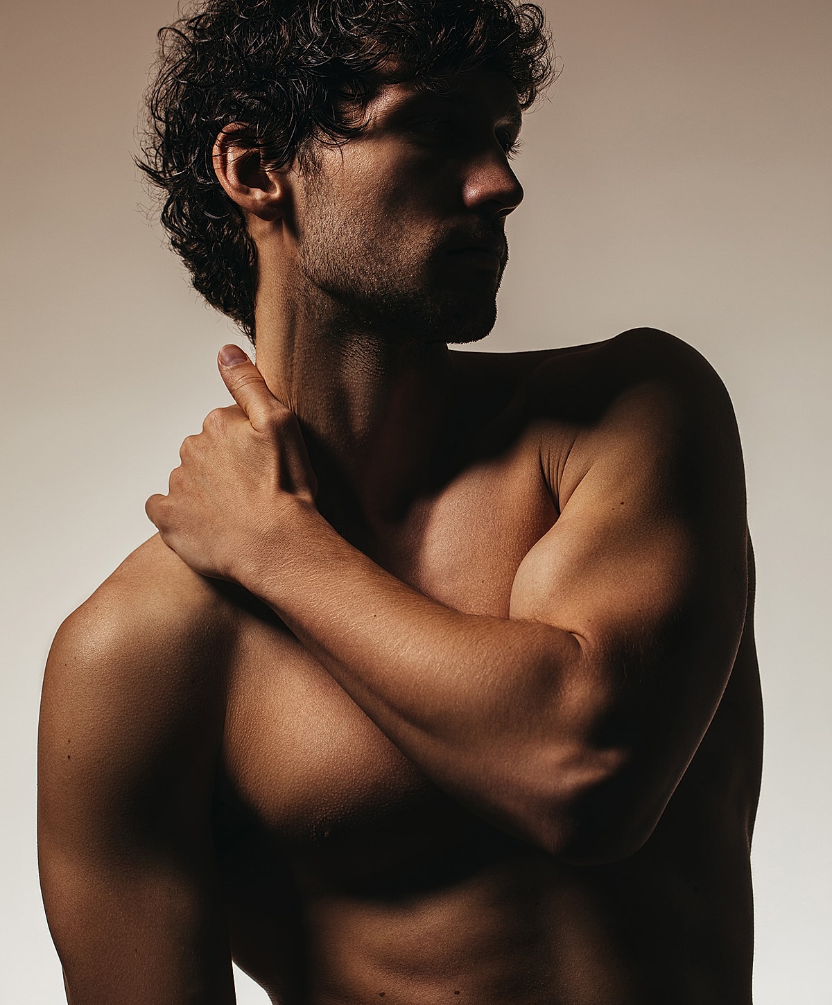 Male figure in dramatic lighting, artistic pose.