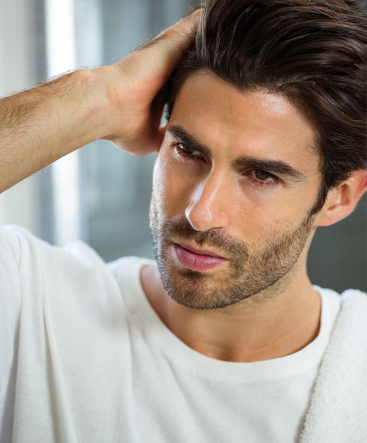 Man styling hair in casual setting