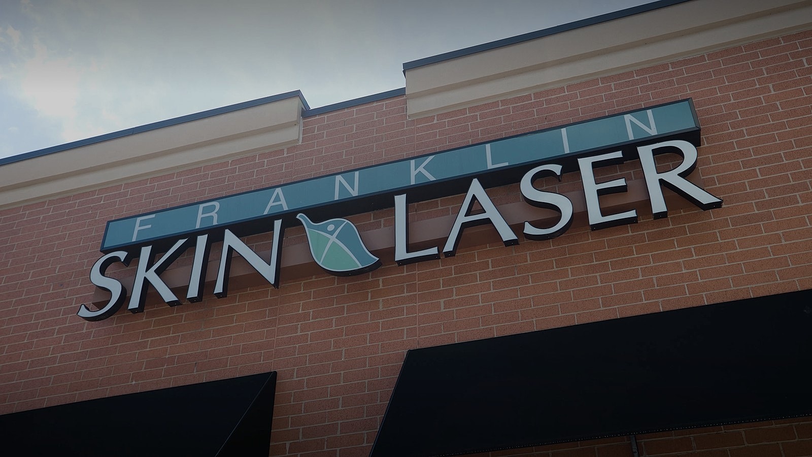 Franklin Skin Laser storefront sign on brick wall